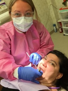 Dental hygienist Katie Schiller treated O+ Festival volunteer Elissa Jane Mastel during the 2014 Festival in Kingston, N.Y.