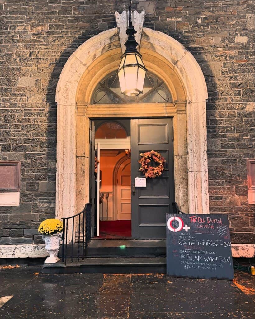 panned out church door with sign displaying festival performances